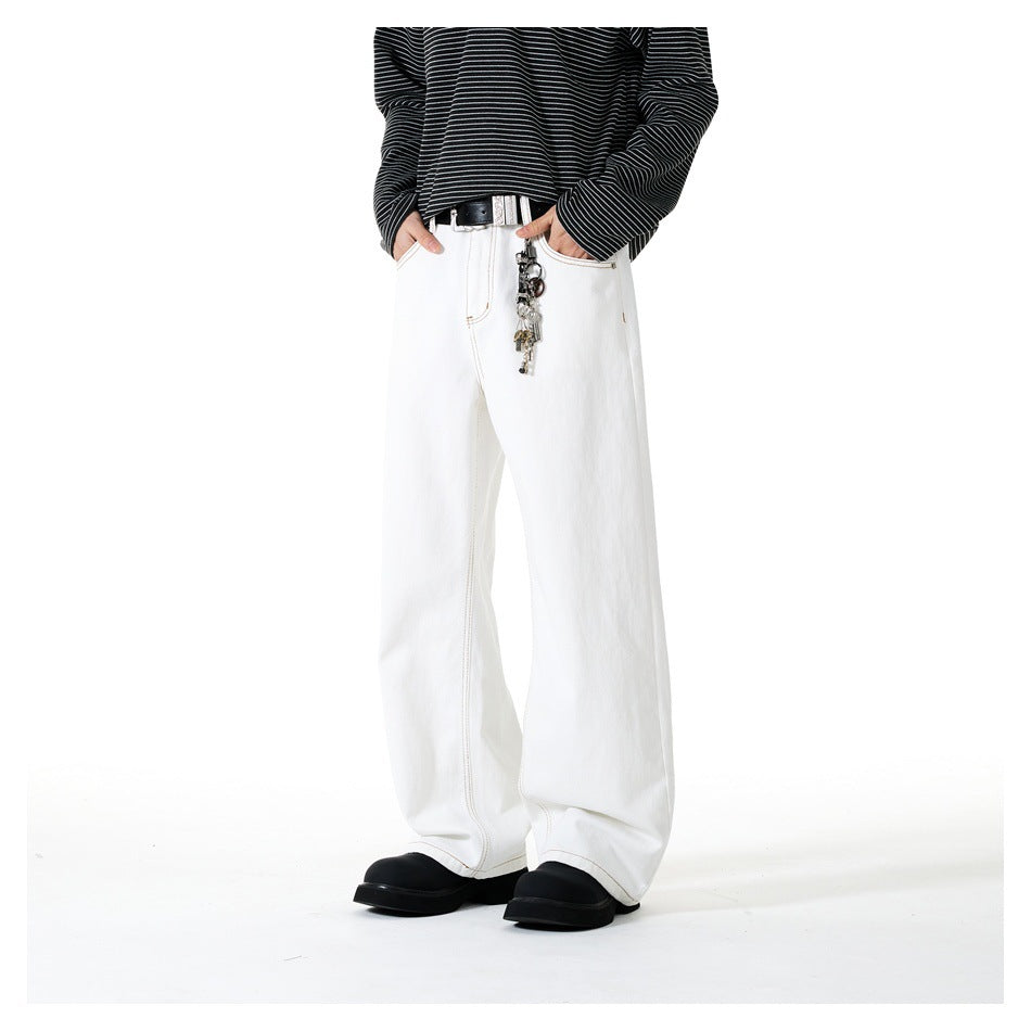 Person wearing white wide-leg jeans with a black belt, key charm and striped long-sleeve top, front view