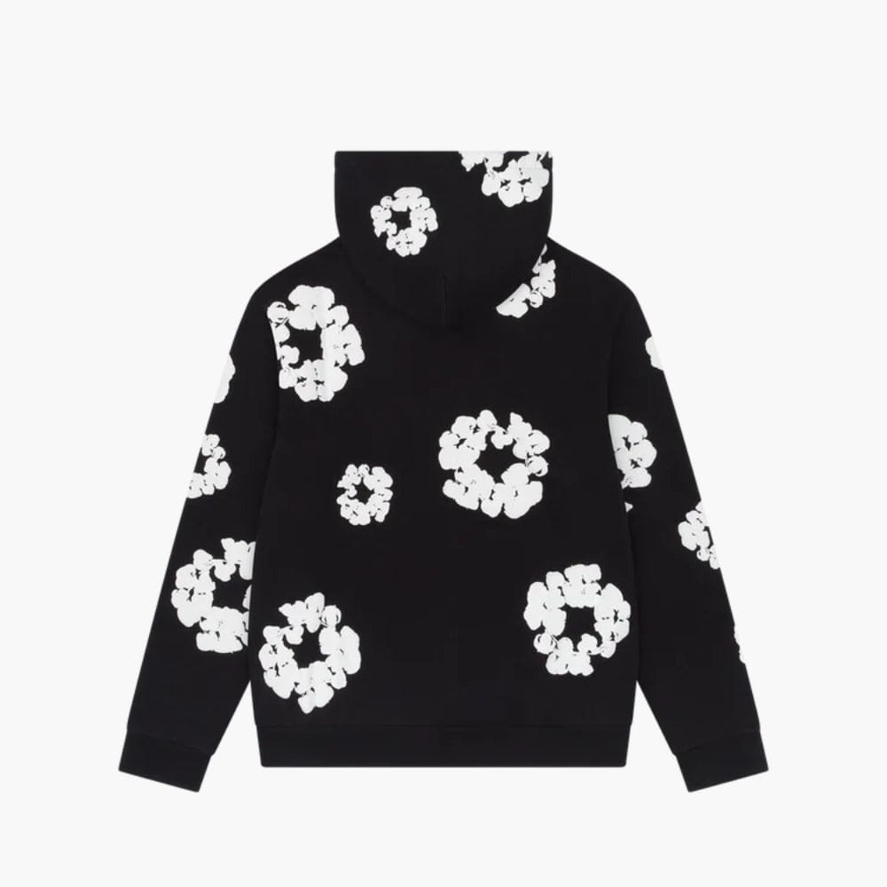 The Black “Cotton Wreath” Denim Tears Hoodie features white floral ring prints scattered on the back and hood, offering a stylish streetwear look inspired by the iconic original.