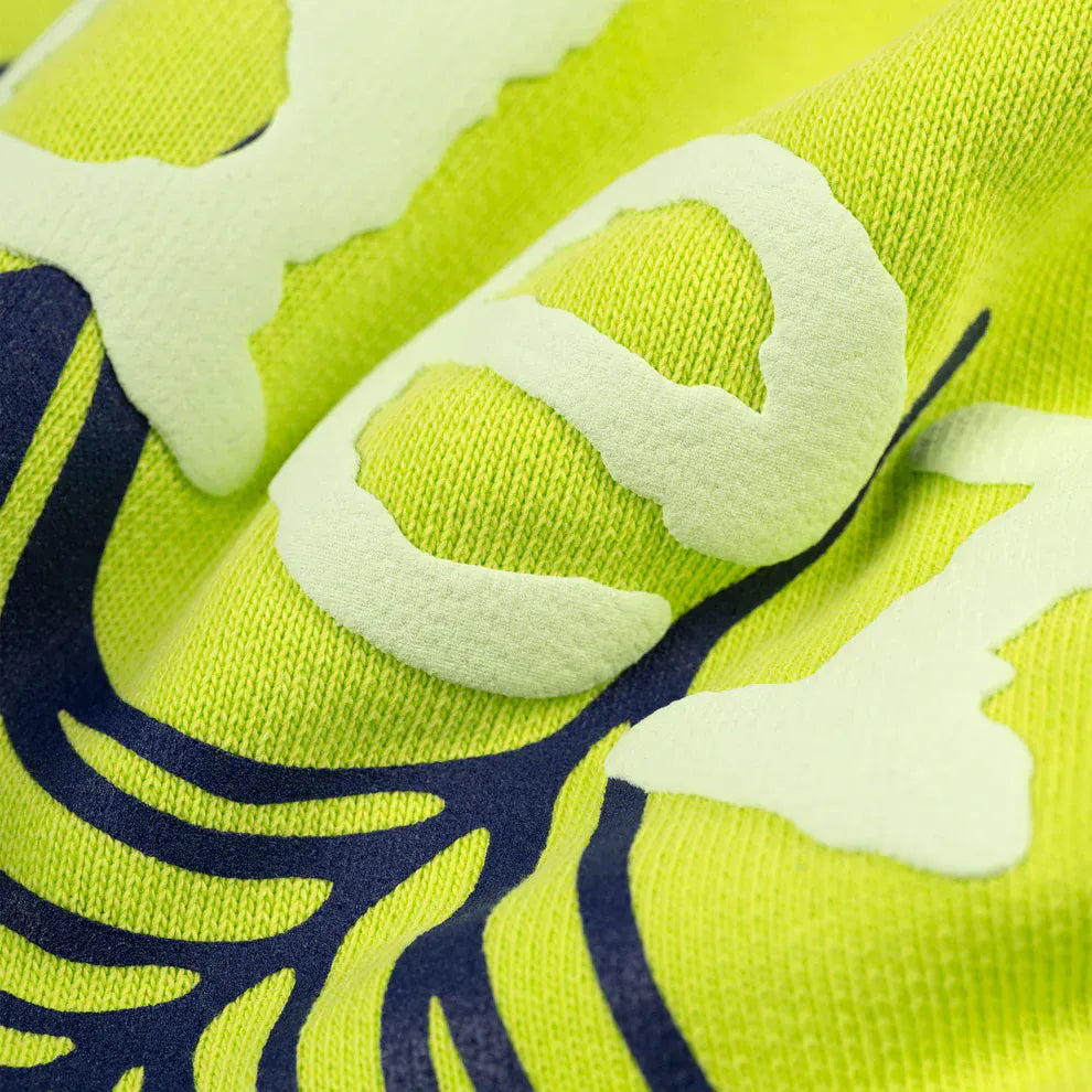 Close-up of the Sp5der Web Graphic Hoodie – Neon Green 440GSM Heavyweight Streetwear, featuring textured yellow-green fabric with raised light and dark blue graphics inspired by classic Sp5der web designs.