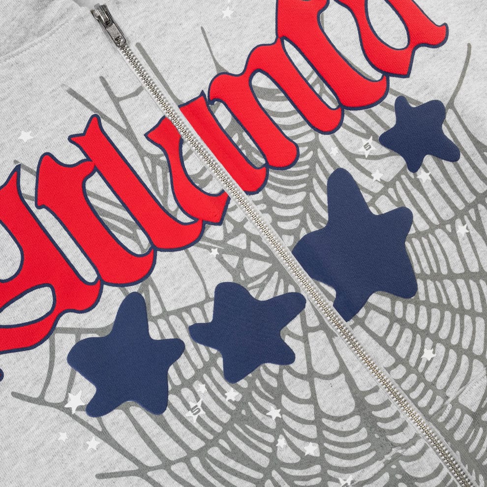 Close-up of the Sp5der Atlanta Web Zip Hoodie – Grey 440GSM Heavyweight Streetwear, featuring grey fabric, a zipper, bold red text, blue stars, and a gray spiderweb graphic—ideal for standout streetwear style.