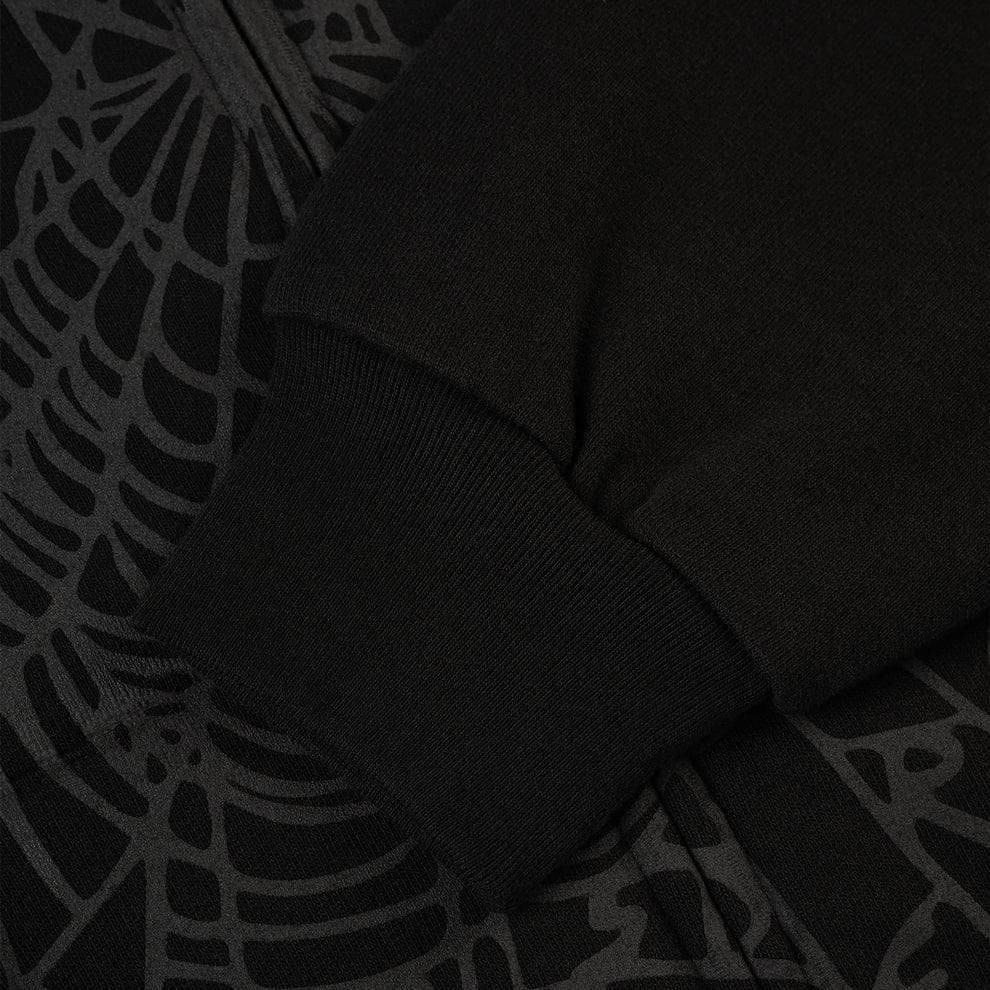 Close-up of a black Sp5der Tonal Web Zip Hoodie – Black 440GSM Heavyweight Streetwear sleeve and cuff, showing a subtle tonal spiderweb pattern in true streetwear style.