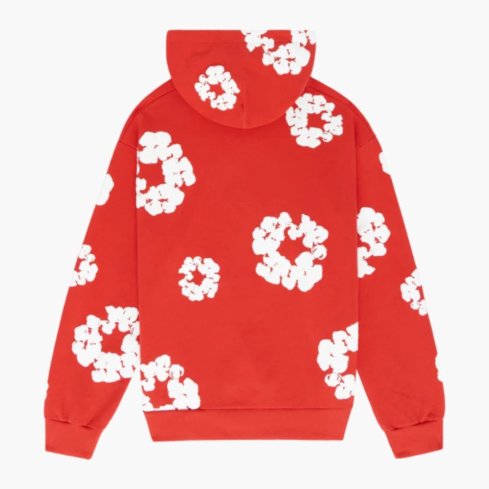 The Red “Cotton Wreath” Denim Tears Hoodie features white floral print designs inspired by cotton wreaths, scattered across the red streetwear pullover.