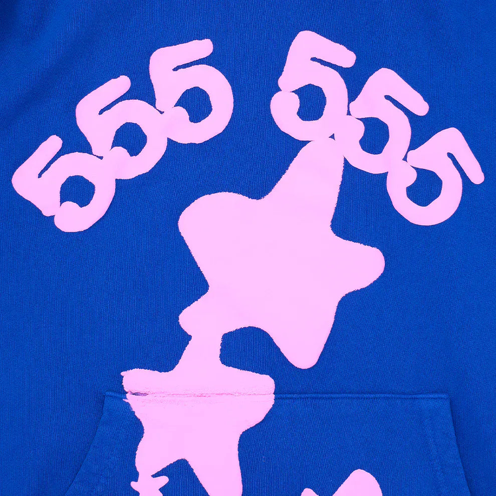 The Sp5der “555 Stars” Hoodie in royal blue features three pink 555 numbers above a large pink star and a smaller star below—signature Y2K-inspired streetwear details on this 440GSM heavyweight oversized pullover.