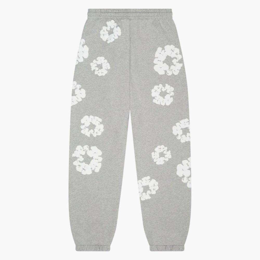 Grey “Cotton Wreath” Denim Tears Sweatpants feature an elastic waistband and cuffs with a white floral print—ideal streetwear for fans of grey pants and unique patterns.