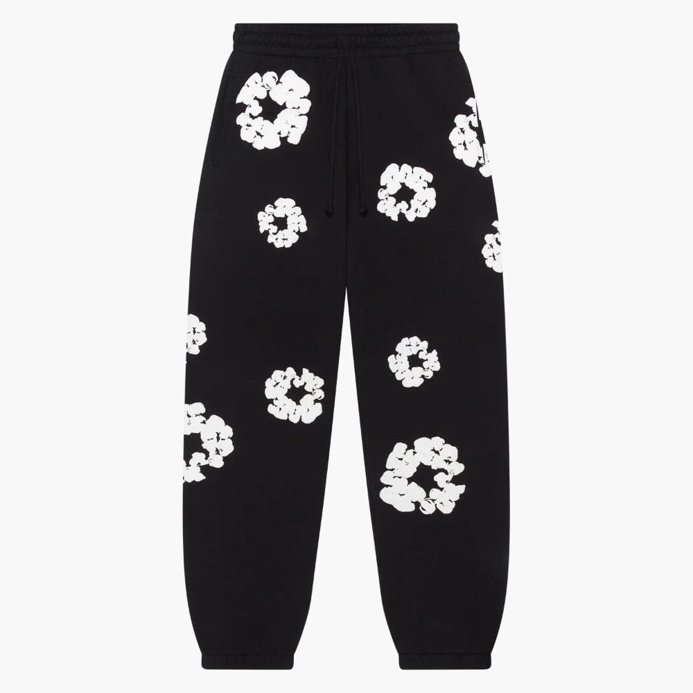 The Black “Cotton Wreath” Denim Tears Sweatpants are streetwear pants with an elastic waistband and cuffs, featuring a white floral print pattern inspired by classic Denim Tears style.