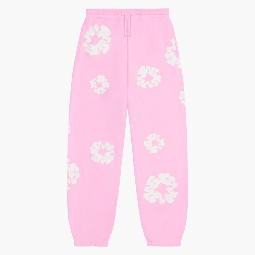 Pink “Cotton Wreath” Denim Tears Sweatpants feature a white floral print on pink streetwear pants, made from cotton with an elastic waistband and cuffs.