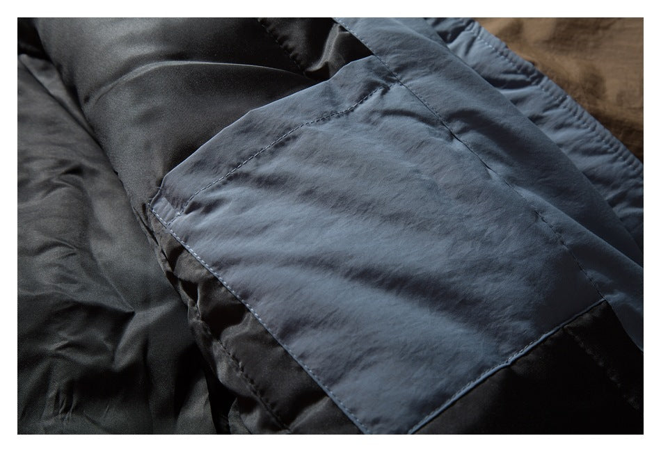 Close-up of a blue-gray jacket pocket and stitching over dark lining.