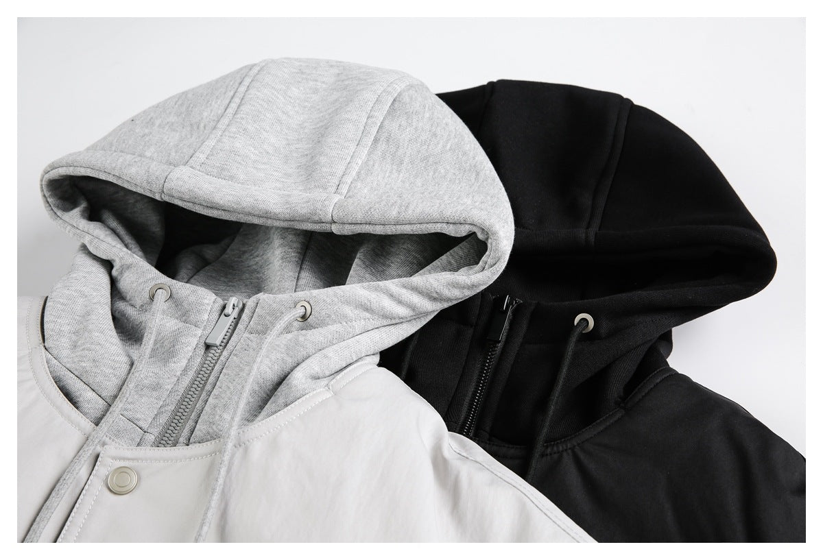 Close-up of light gray and black jacket hoods, showing drawstrings, metal eyelets, and front zippers.