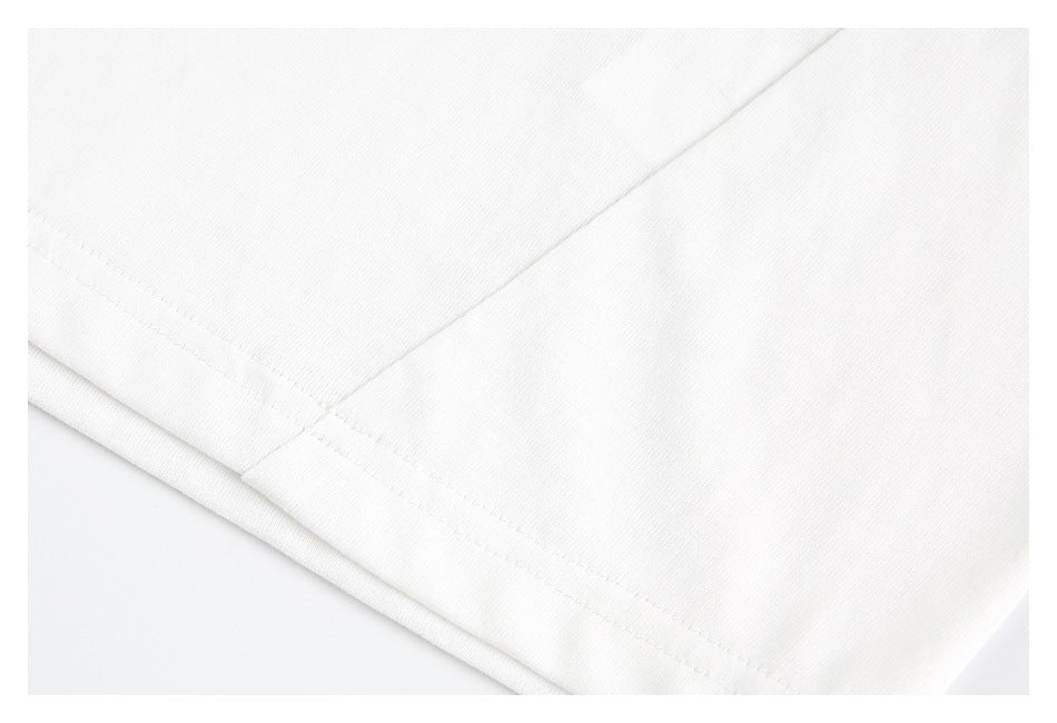 Close-up of the white T-shirt's stitched lower hem and fabric seam.