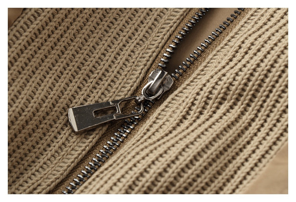 Close-up of a metal zipper between two ribbed knit sections of a tan jacket.
