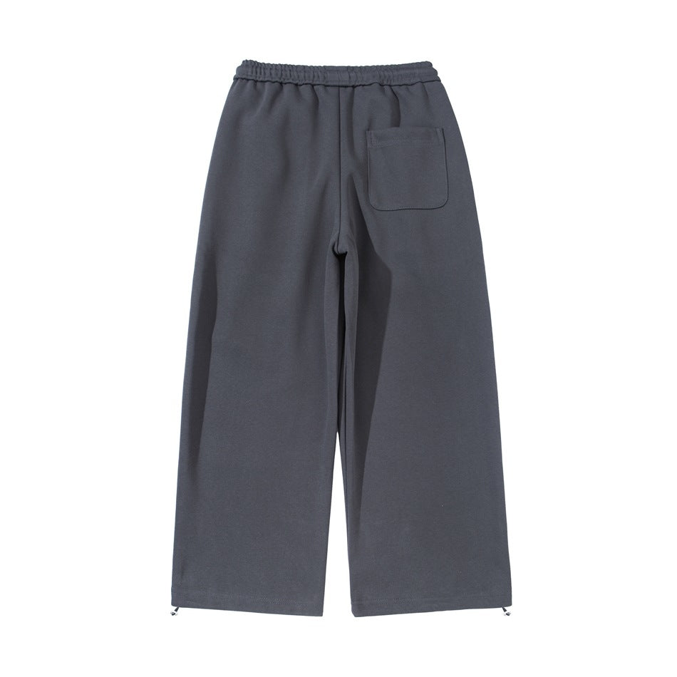 Back view of gray wide-leg pants with an elastic waistband, one patch pocket and metal hem adjusters.
