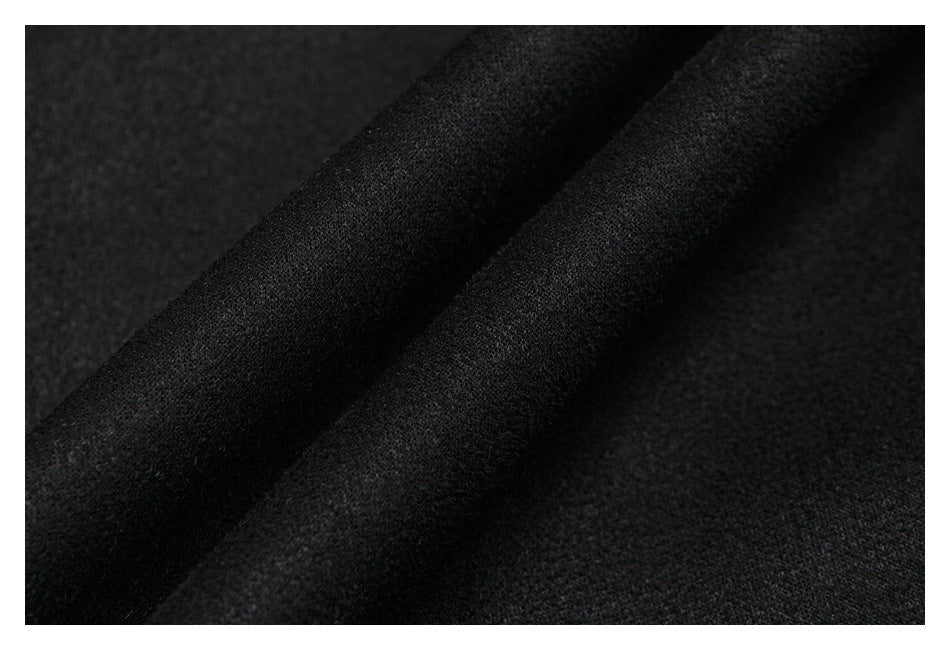 Close-up of black garment fabric draped in folds, showing its soft-looking surface texture.