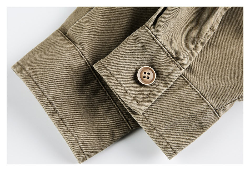 Close-up of a tan garment cuff with a four-hole button and visible stitching.