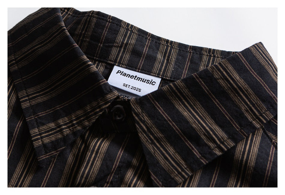 Close-up of the pointed collar, button, and sewn-in label on a dark shirt with brown stripes.