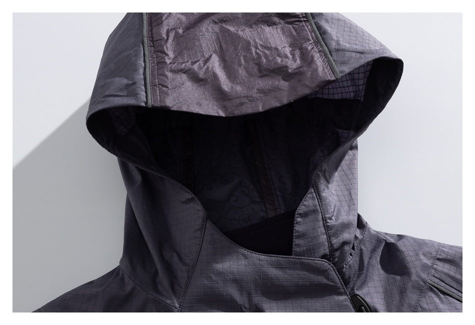 Close-up of the charcoal jacket's large hood, showing its dark patterned lining and high front collar.