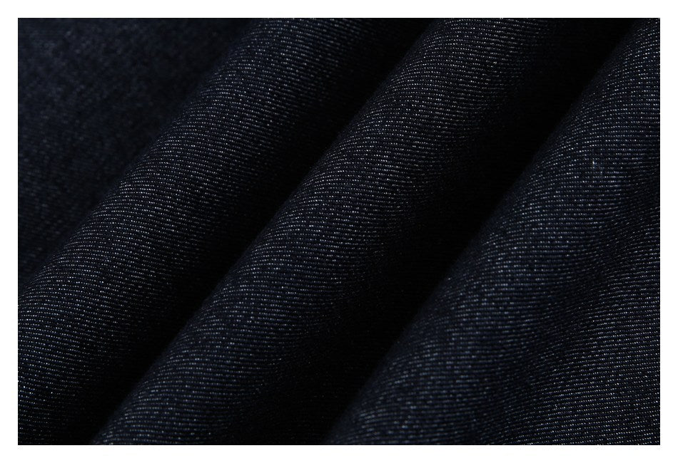 Close-up of dark navy fabric with a fine woven texture and soft folds.