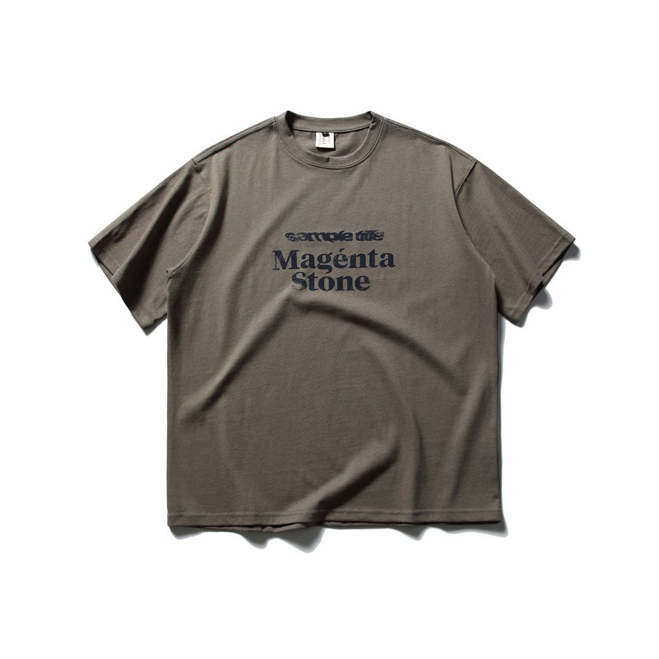 Dark gray short-sleeve crew-neck T-shirt with navy 'Magénta Stone' text print on the chest, flat lay