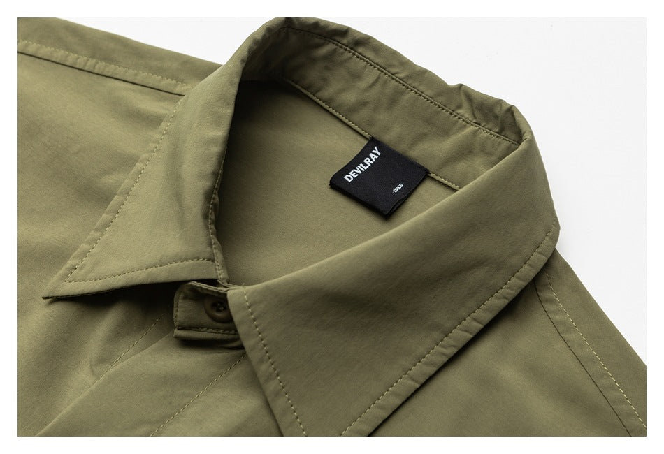 Close-up of an olive-green shirt collar and button with a black DEVILRAY neck label.