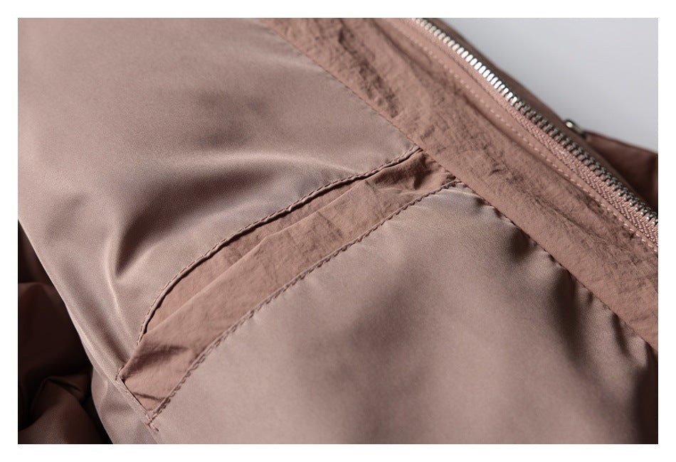 Close-up of a stitched seam and pocket opening beside the jacket's zipper.