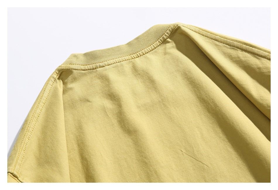 Close-up of the pale yellow T-shirt back neckline and shoulder seams.