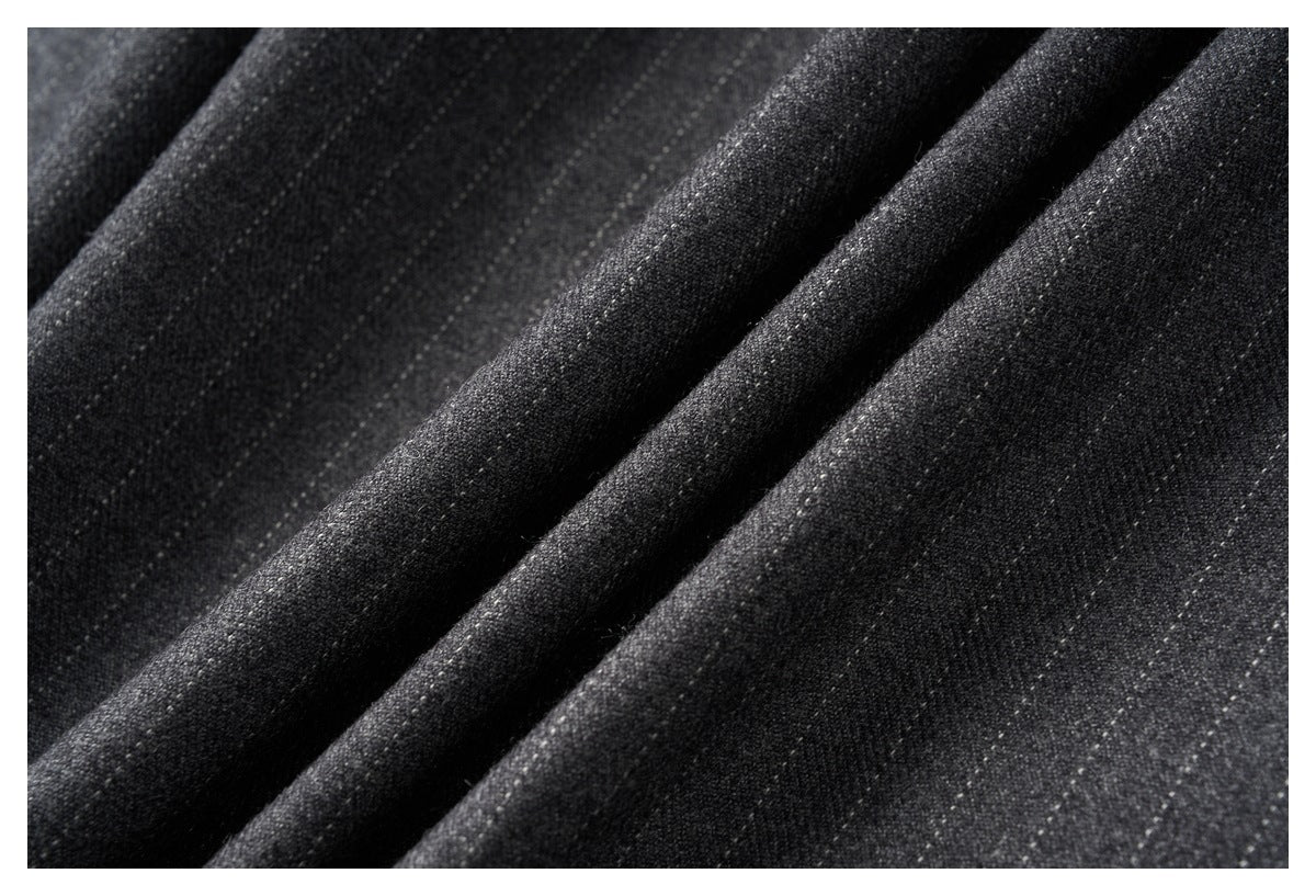 Macro view of the charcoal gray trousers' textured fabric and soft folds.