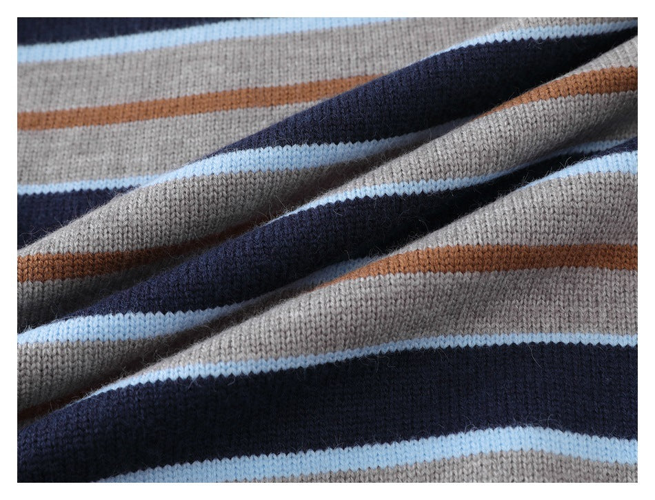 Close-up of folded gray and navy sweater knit with pale blue and rust stripes.