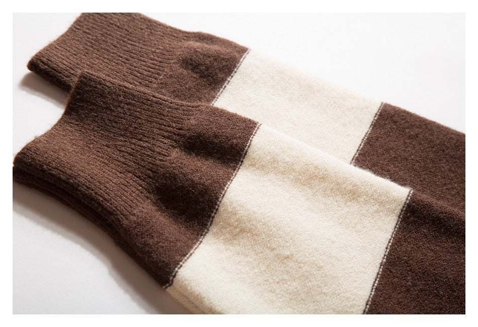 Two dark brown ribbed cuffs lie flat against a cream and brown striped knit garment.