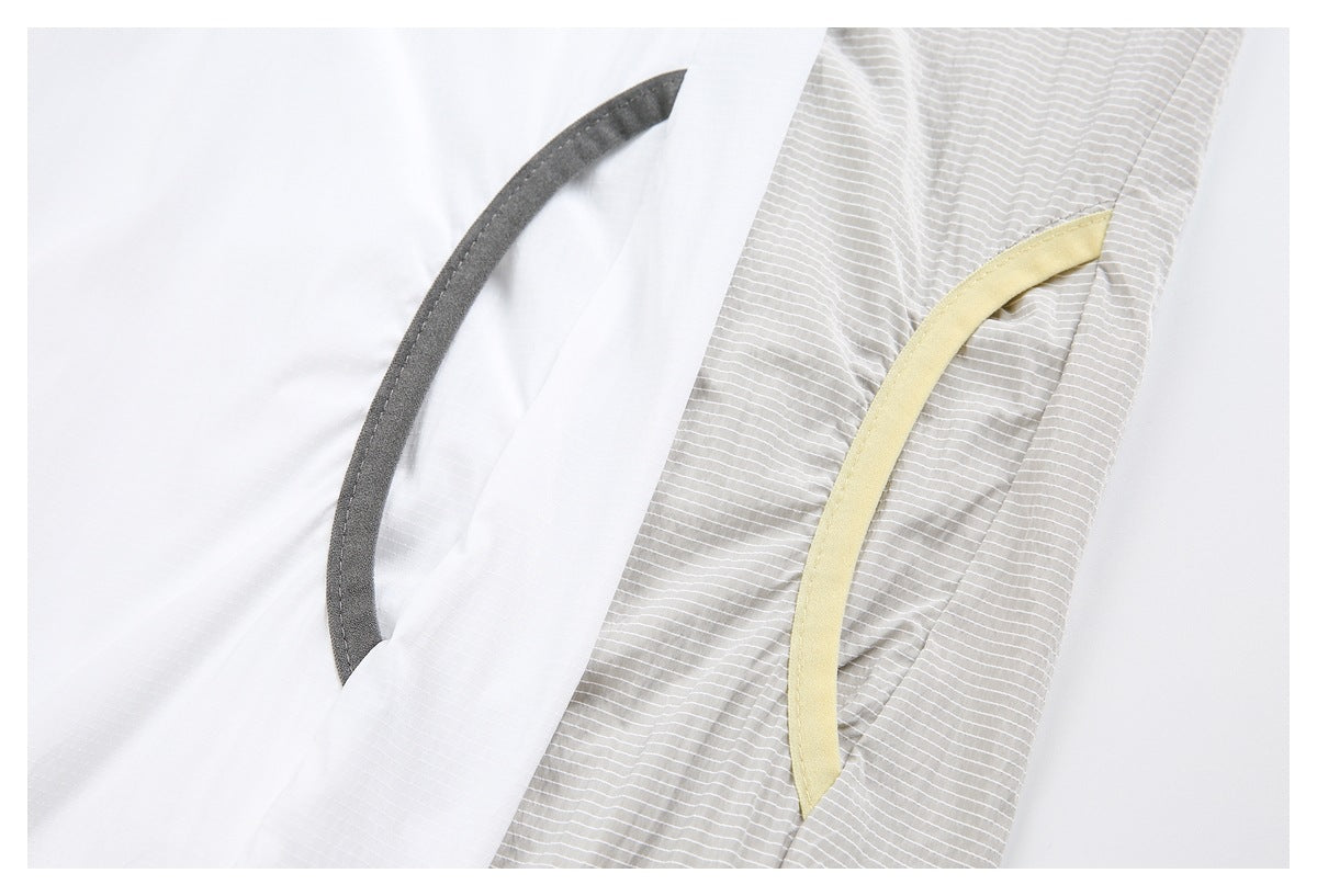 Close-up of white and fine-striped fabric with curved dark gray and pale yellow trim.