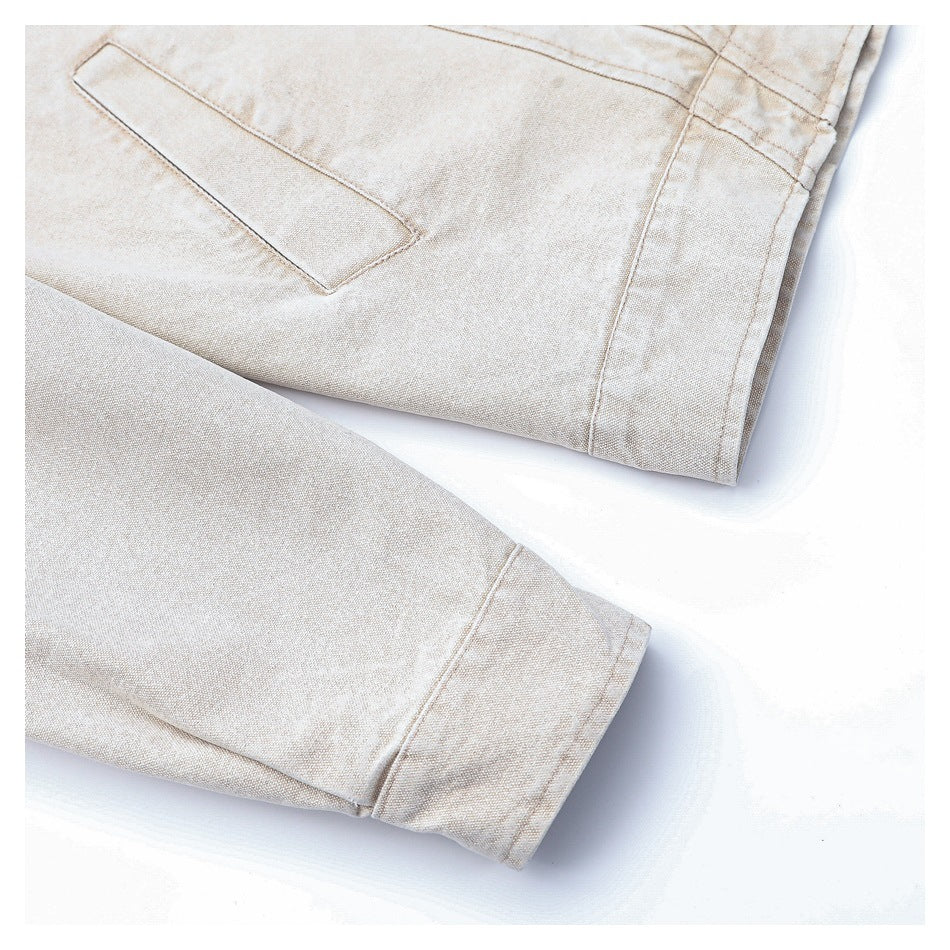 Close-up of a light beige jacket sleeve cuff beside a slanted pocket opening.