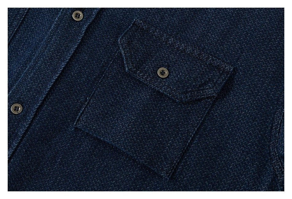 Close-up of a dark navy patterned shirt with a flap chest pocket and brown buttons.