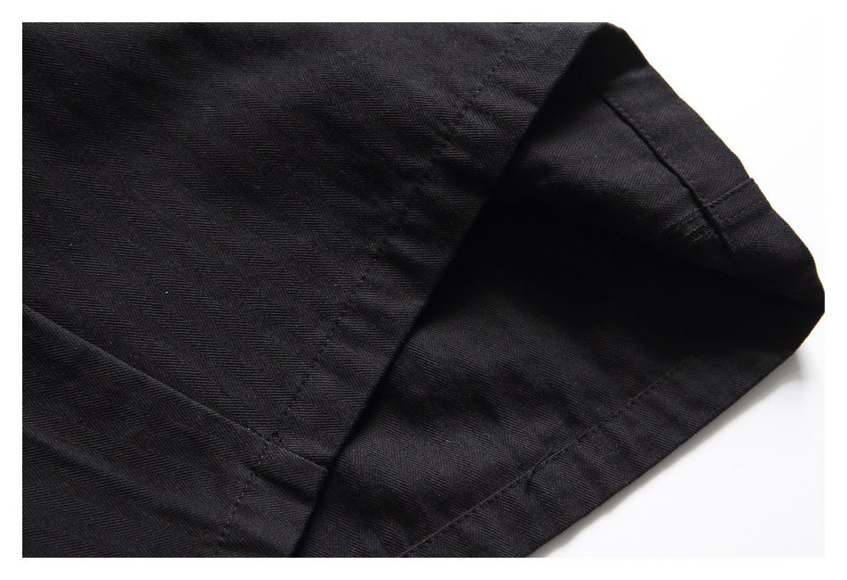 Close-up of the stitched hem and edge of a black shorts leg.