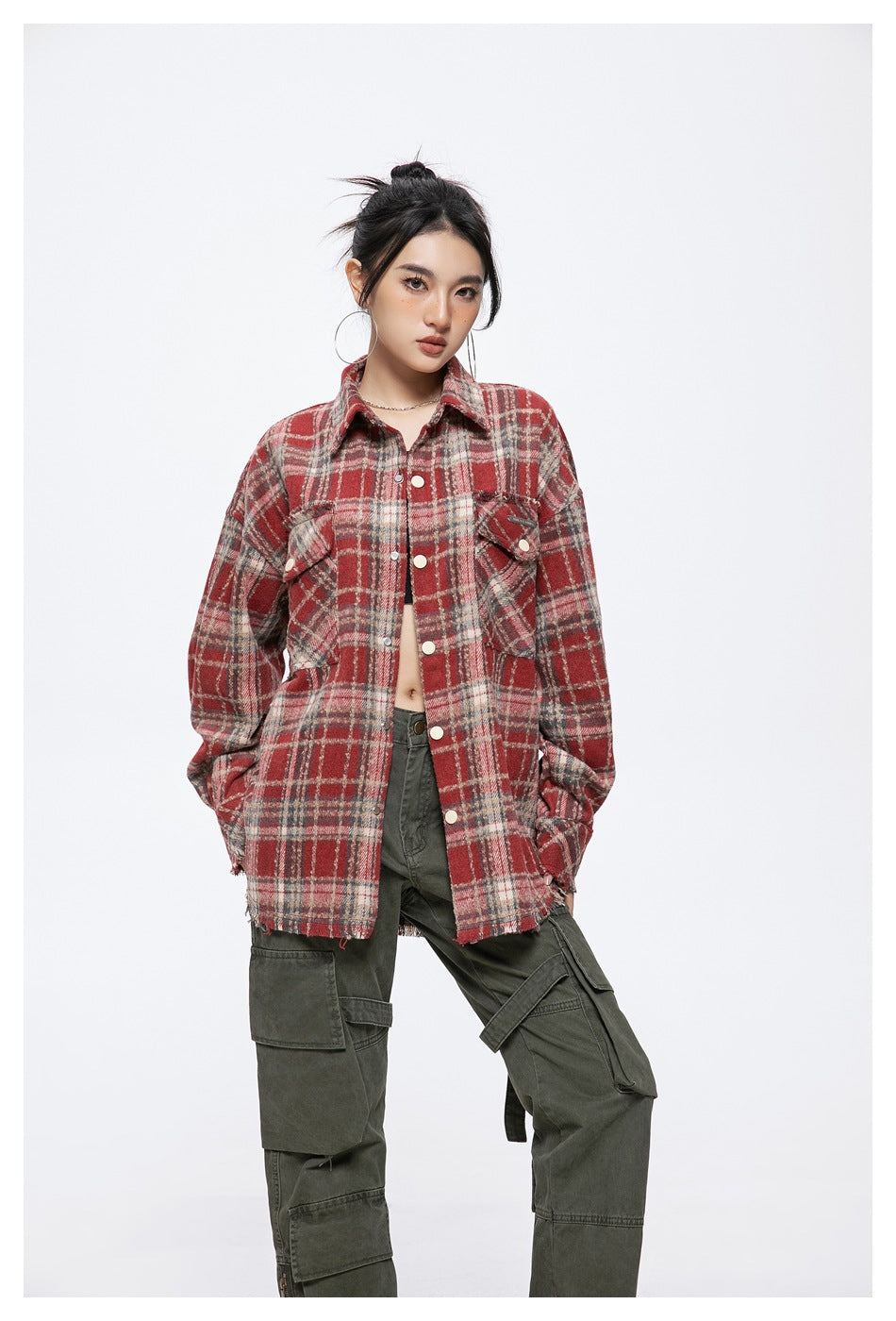 Model wearing an oversized red plaid shirt jacket with snap buttons, flap pockets, and a frayed hem.