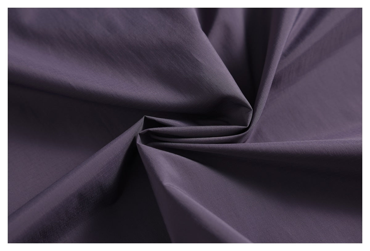 Close-up of the dark purple jacket fabric, showing its fine grid texture and folds.