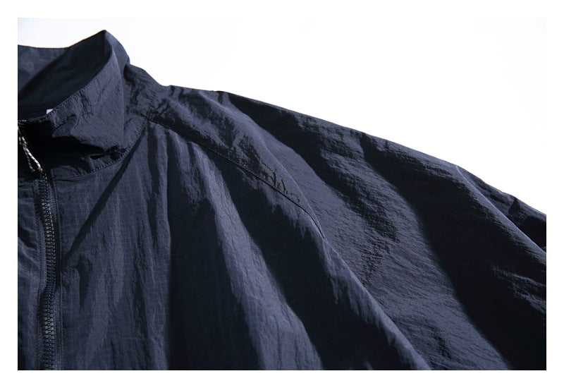 Close-up of the jacket's stand collar, shoulder seam and dark navy fabric.