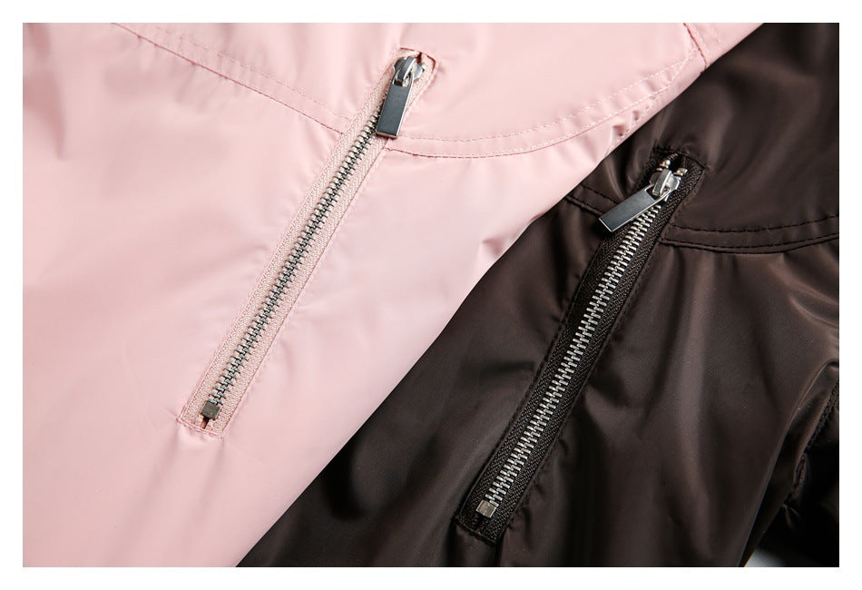 Close-up of pale pink and dark brown jackets with vertical zip pockets and metal pulls.