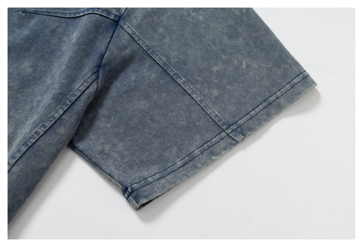 Close-up of a short sleeve and double-stitched cuff on mottled blue fabric.