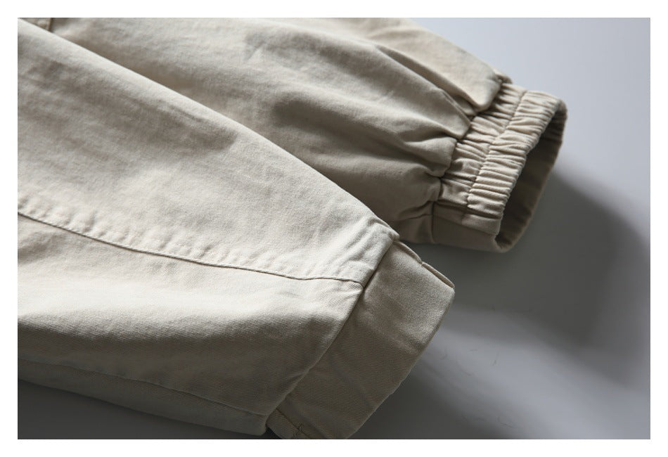 Close-up of a light beige jacket sleeve, showing its seam and gathered elastic cuff.