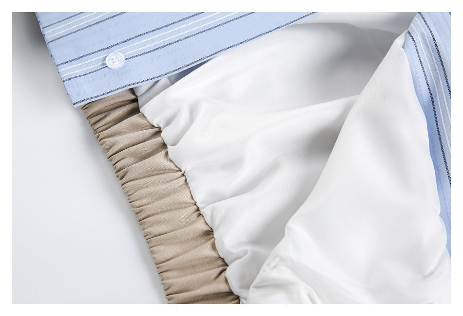 Close-up of beige garment lining and gathered waistband beside light blue striped fabric.