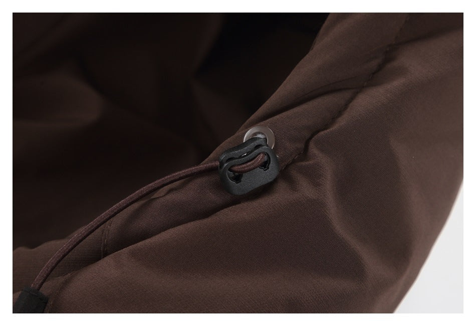 Close-up of a dark brown jacket drawcord with a black toggle and grommet.