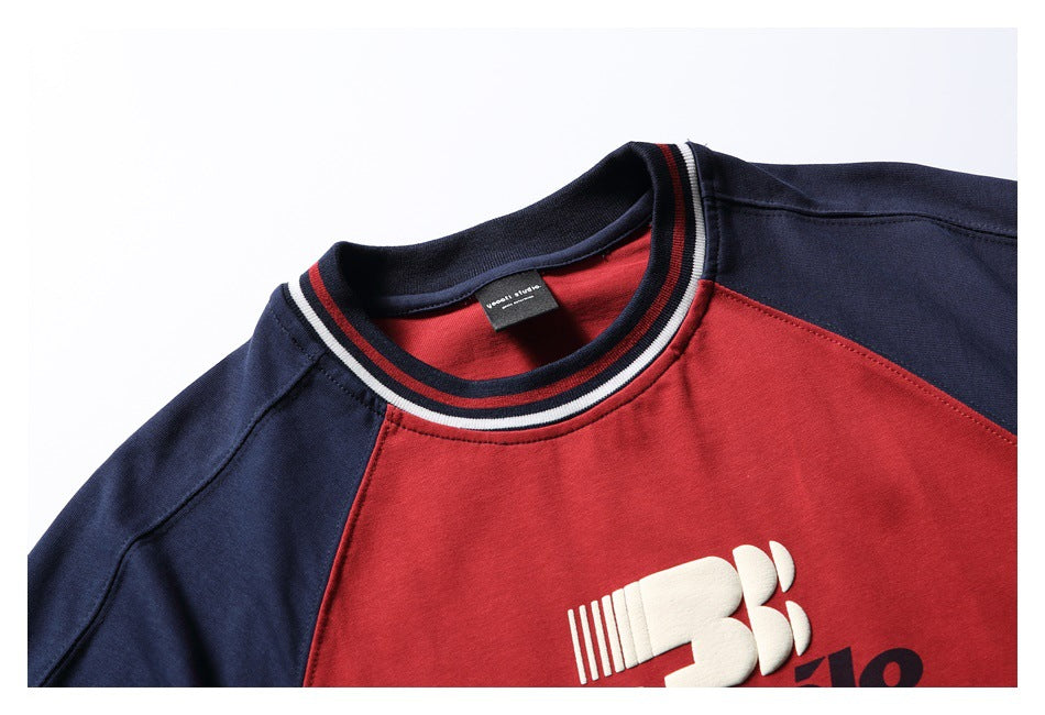 Close-up of the red-and-navy T-shirt neckline, striped ribbed collar, and part of its chest graphic.