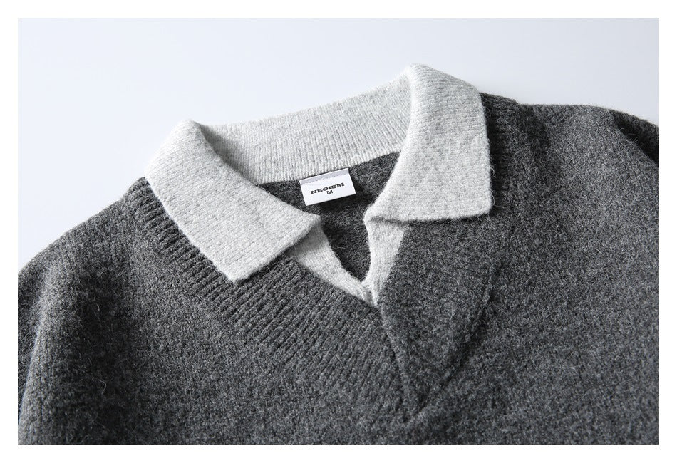 Close-up of a charcoal gray knit sweater with a light gray contrast collar and a small neck label.