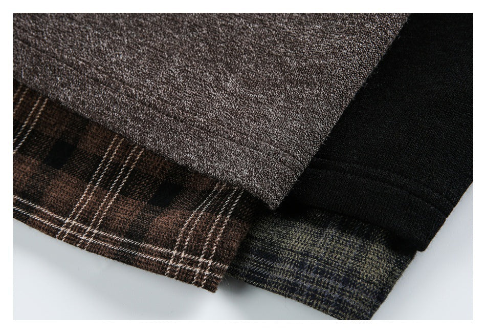 Close-up of a brown textured jacket layered with brown plaid and dark fabric panels.