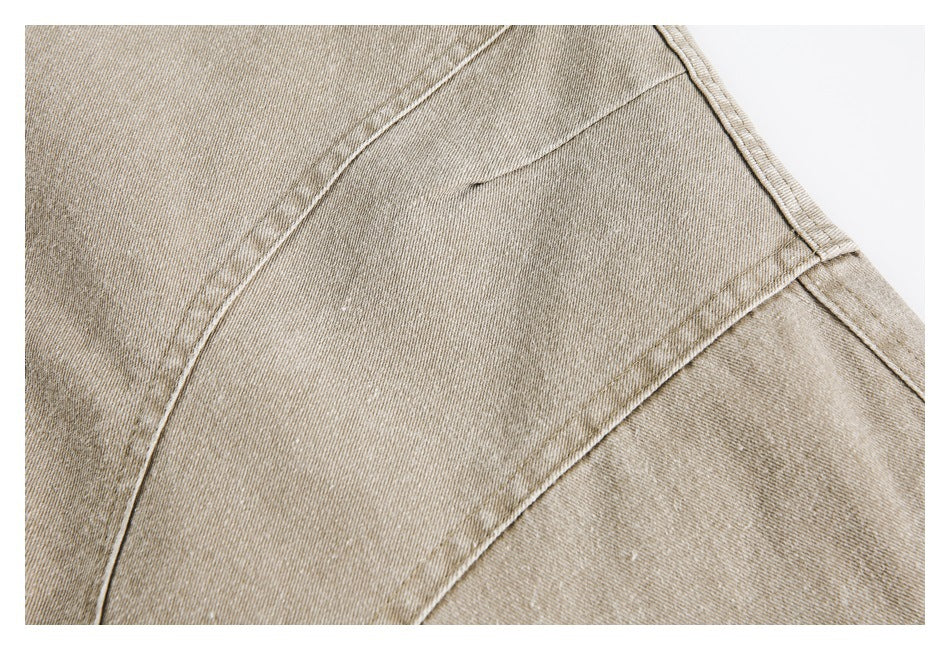 Close-up of tan jacket fabric and intersecting stitched seams.
