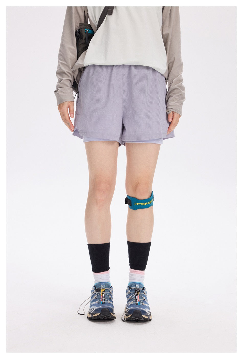 Front view of a model wearing light lavender running shorts over matching compression shorts.