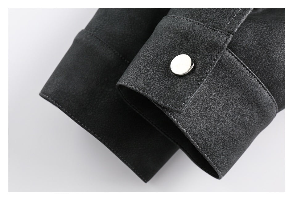 Close-up of a black garment cuff with a silver snap button and visible stitching.