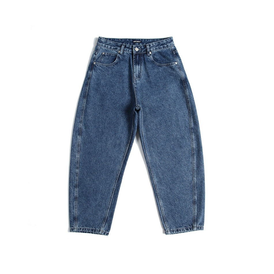 Front view of blue washed denim jeans with a curved-leg, tapered cropped silhouette on a white background
