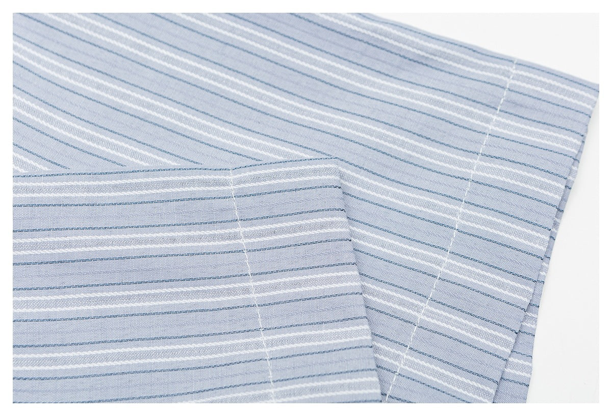 Close-up of a striped pale blue shirt sleeve and folded cuff.