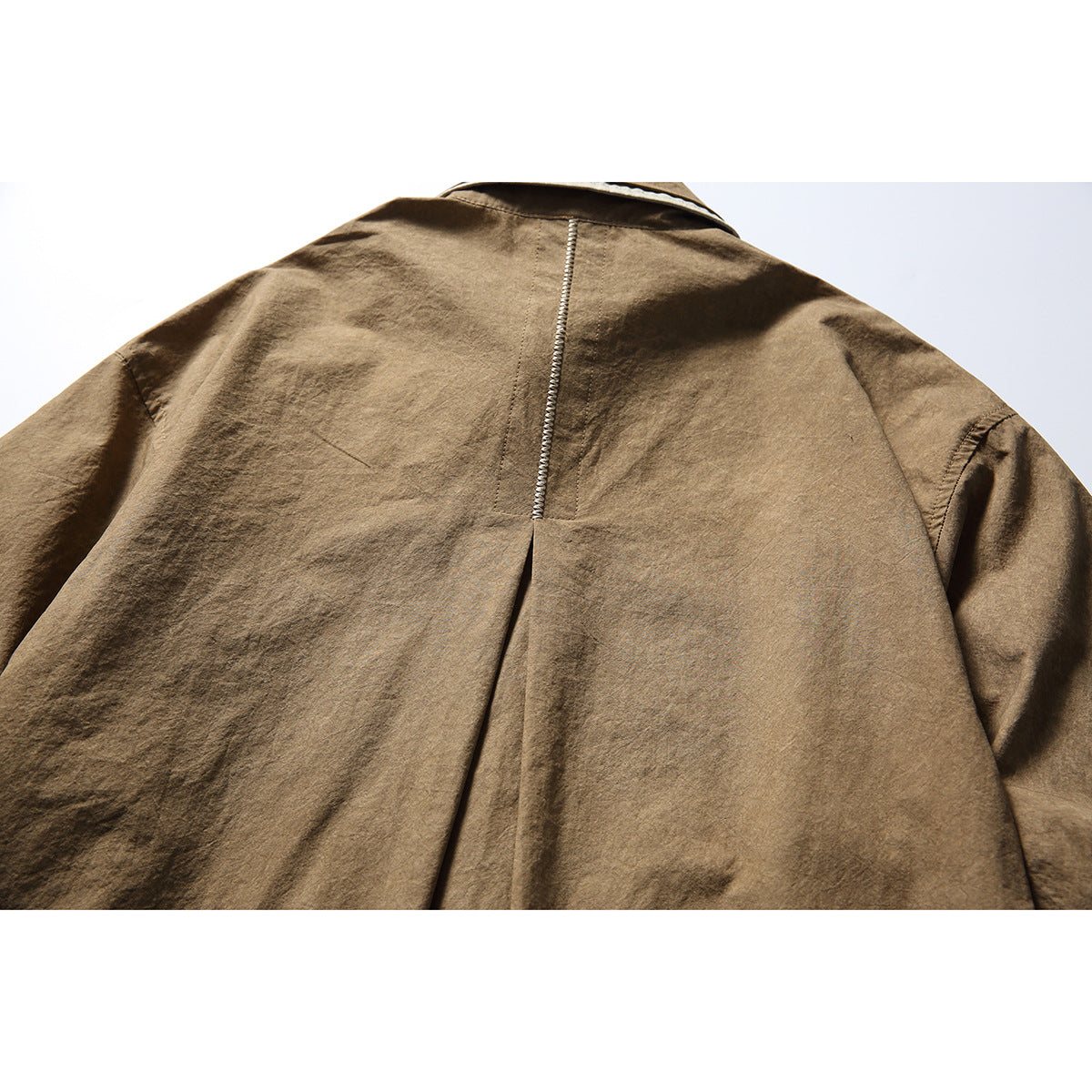Close-up of the brown shirt's back, showing the center seam and pleat.