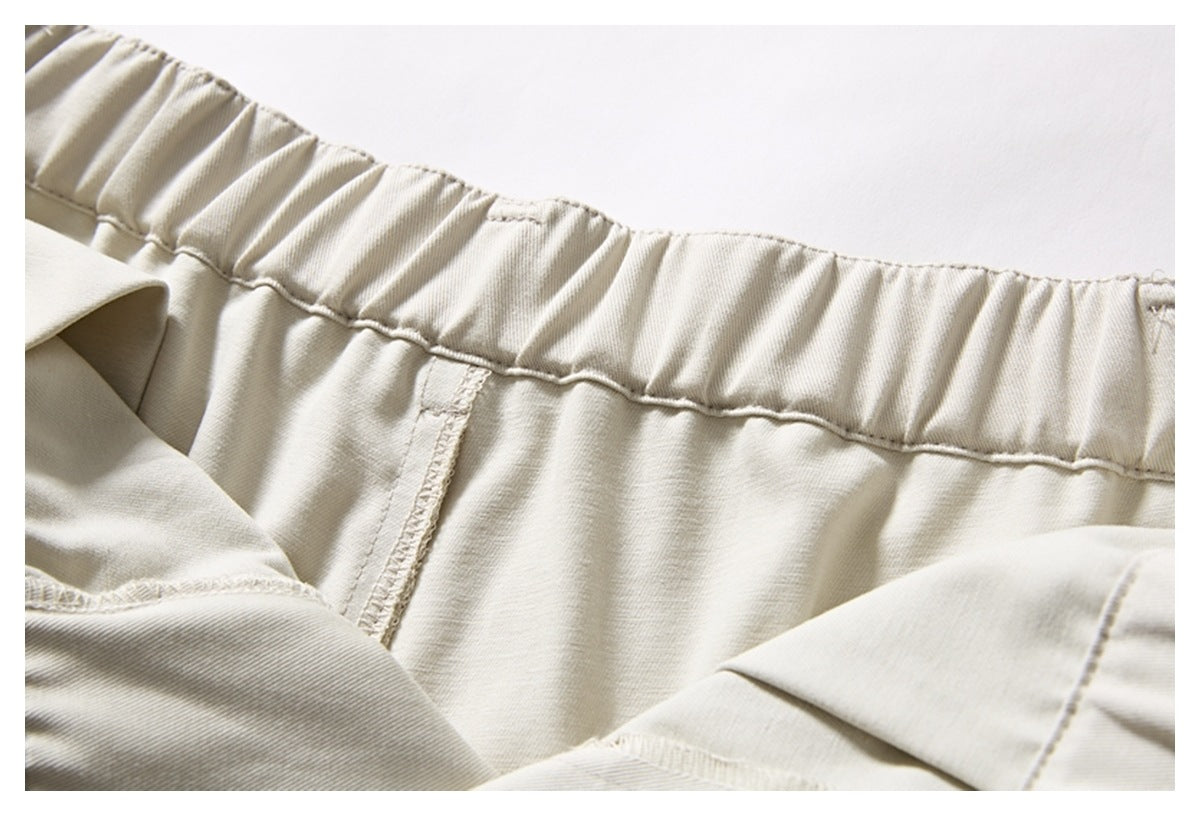 Close-up of a light beige garment showing a gathered elastic waistband and stitched seams.