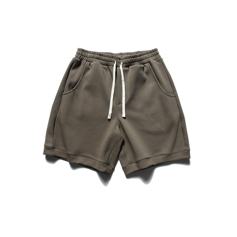 Brown drawstring shorts with elastic waistband, side pockets and turned hems, flat lay front view